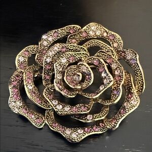vintage rose brooch featuring an open-work gold-tone with small pink rhinestones